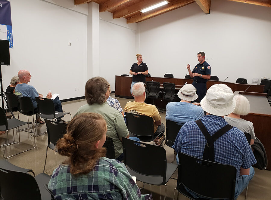Alison Green, left, and Chad Hawkins of the Oregon Office of State Fire Marshal discuss defensible space codes Tuesday at a community meeting in Detroit. About a dozen residents participated in the 90-minute session.