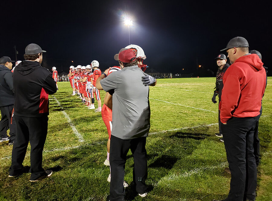 Wolverines coach Josh Ruby hugs a player during Senior Night ceremonies on Oct. 27 in Mill City.