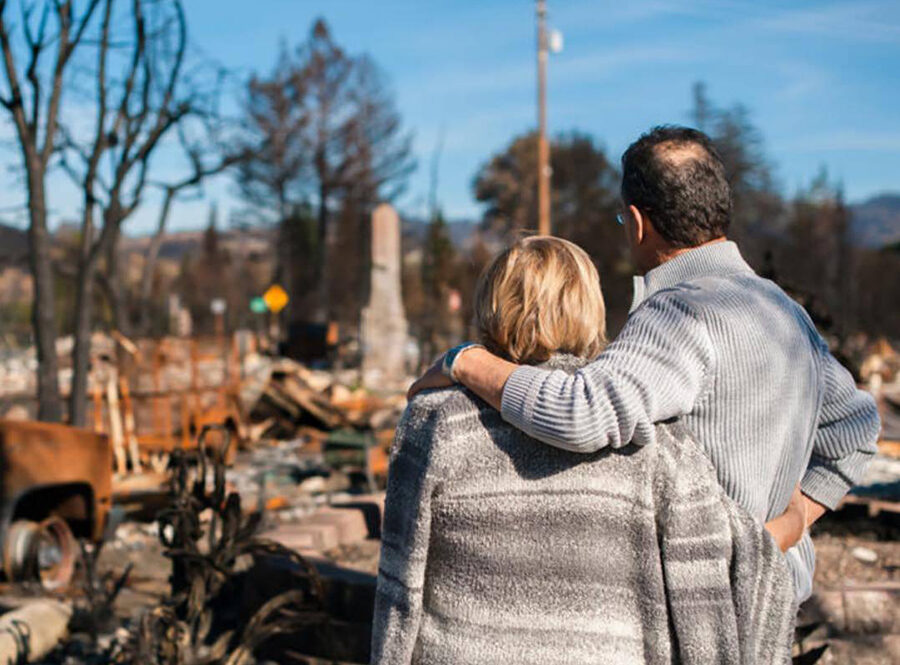A couple review a home following the 2020 fires. For many, rebuilding is ongoing.