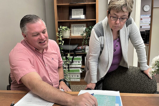 Steve Braaten, Linn County technology director, reviews a county map with Commissioner Sherrie Sprenger. The county is working on a project to try to identify and address internet gaps in rural areas. Alex Paul, Linn County