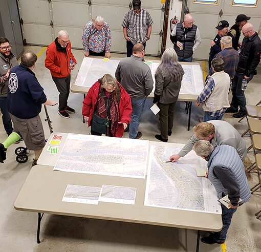 Participants at an April 24 public outreach meeting on Marion County’s draft plan for restoring county parks in the Santiam Canyon crowd around the tables at the Elkhorn Fire Station. James Day