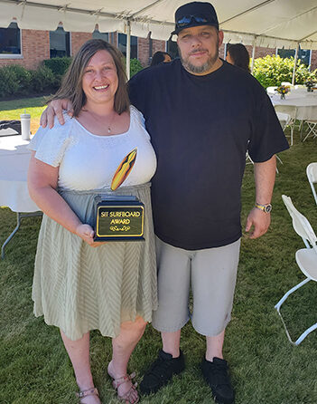 Lisa Brunson, with her husband Justin, was awarded the Santiam Service Integration Surfboard award at the June 29 end of year celebration. SUBMITTED PHOTO
