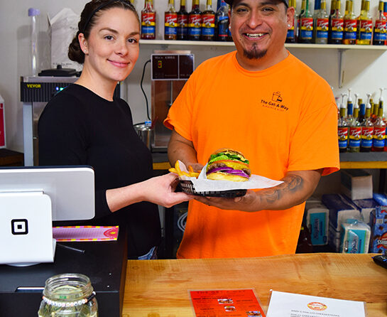 The Get-A-Way owner Ashley Yardley, left, shows off one of their signature smash-burgers with husband Adalid Garcia at the restaurant’s new location at 218 Santiam Blvd., in Mill City. Janet Patterson